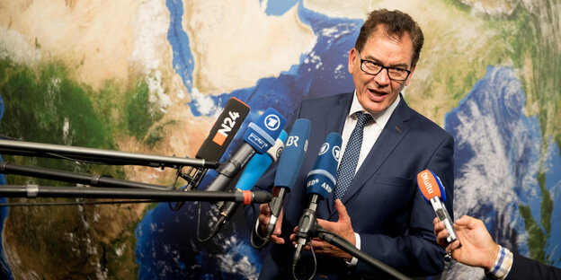 Entwicklungsminister Müller steht vor einer Weltkarte und spricht in Mikrofone. Entwicklungsminister Müller steht vor einer Weltkarte und spricht in Mikrofone.