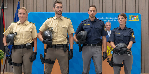 Polizisten mit alter und neuer Polizeiuniform stehen nebeneinander Polizisten mit alter und neuer Polizeiuniform stehen nebeneinander