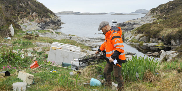 Ein Freiwilliger sammelt Müll vor der Küste Norwegens ein Ein Freiwilliger sammelt Müll vor der Küste Norwegens ein