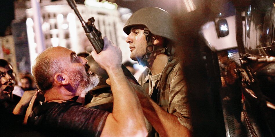 Ein Bürger greift nach dem Maschinengewehr eines jungen Soldaten