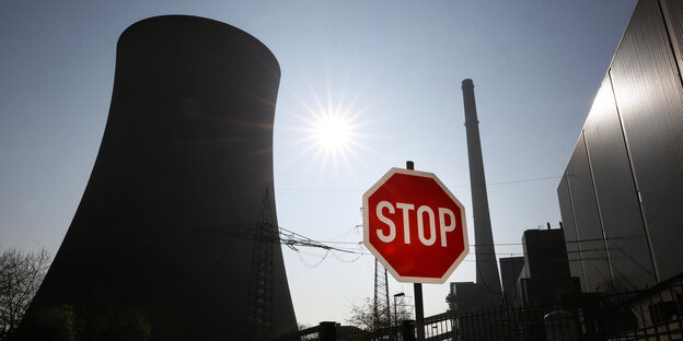 Vor einem Kohlekraftwerk steht ein Stop-Schild Vor einem Kohlekraftwerk steht ein Stop-Schild