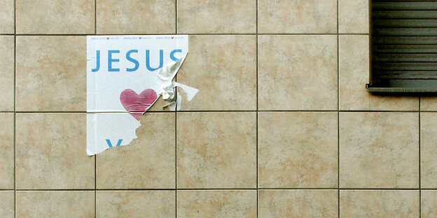 Ein zerflettertes Plakat klebt an einer Wand. Jesus steht drauf. Der Rest ist abgerissen. Ein zerflettertes Plakat klebt an einer Wand. Jesus steht drauf. Der Rest ist abgerissen.