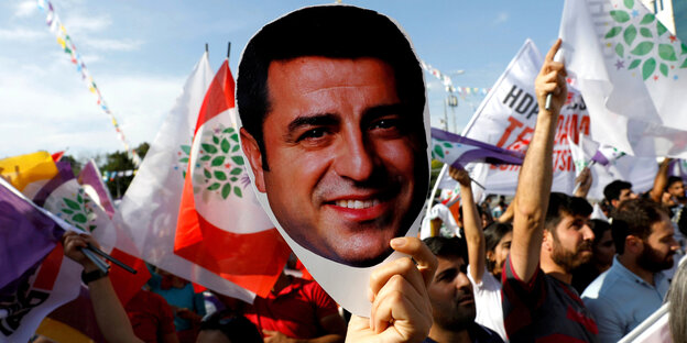 Demonstranten halten ein Bild mit Selahattin Demirtaş hoch Demonstranten halten ein Bild mit Selahattin Demirtaş hoch