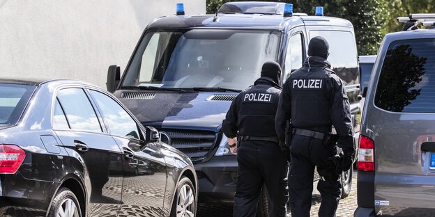 Polizisten vor einem Haus bei einer Razzia gegen Prepper