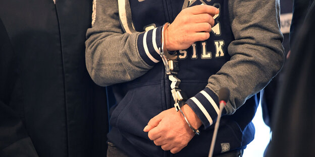 Ein Angeklagter in Handschellen Ein Angeklagter in Handschellen