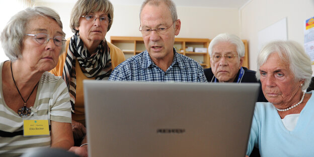 Fünf ältere Menschen blicken auf einen Computerbildschirm Fünf ältere Menschen blicken auf einen Computerbildschirm