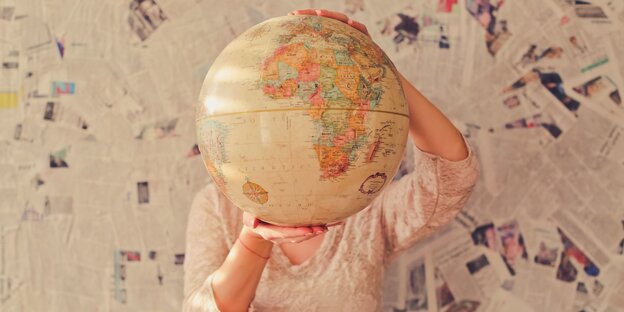 Eine Frau hält einen Globus Eine Frau hält einen Globus