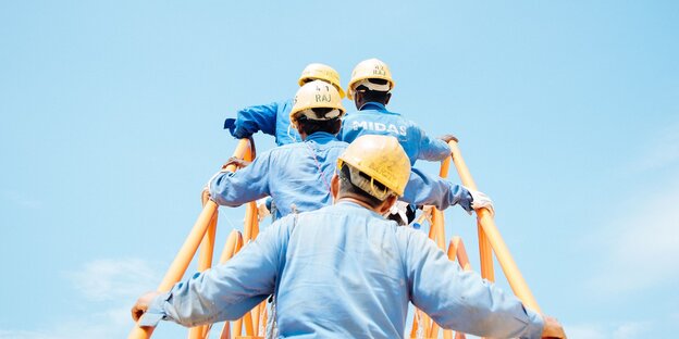 Mehrere Bauarbeiter steigen eine Treppe auf Mehrere Bauarbeiter steigen eine Treppe auf
