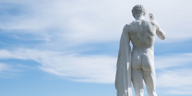 Eine antike Männerstatue von hinten Eine antike Männerstatue von hinten