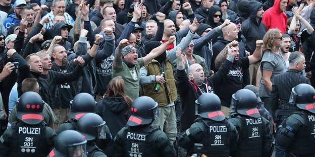 Polizisten stehen vor rechten Demonstranten Polizisten stehen vor rechten Demonstranten