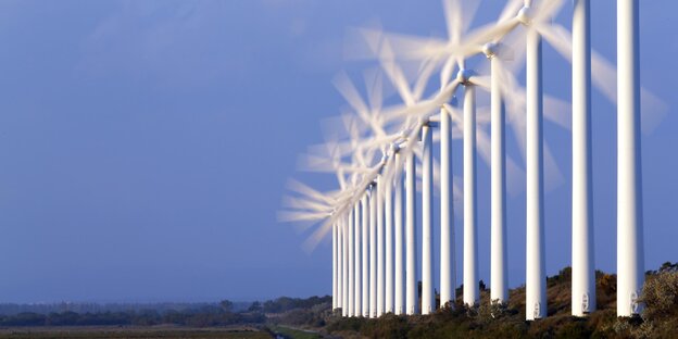 Eine Reihe von Windkrafträdern, deren Blätter sich drehen Eine Reihe von Windkrafträdern, deren Blätter sich drehen