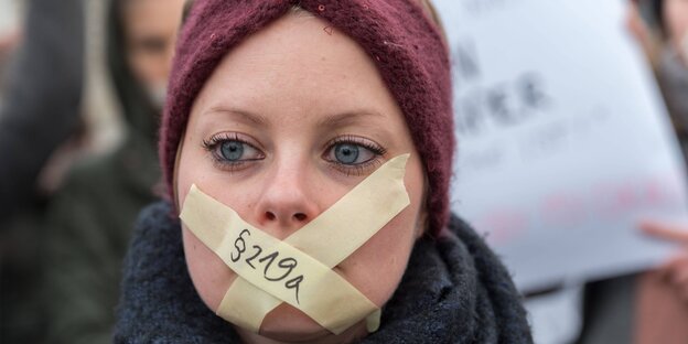 Frau mit zugeklebtem Mund auf Demo Frau mit zugeklebtem Mund auf Demo