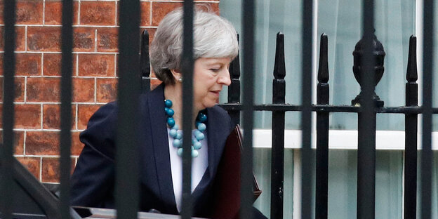 Theresa May ist in der Downing Street hinter einem Zaun zu sehen Theresa May ist in der Downing Street hinter einem Zaun zu sehen