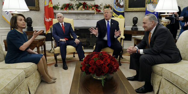 Vier Politiker_innen sitzen im Oval Office zusammen. Es sind Nancy Pelosi, Mike Pence, Donald Trump und Chuck Summer Vier Politiker_innen sitzen im Oval Office zusammen. Es sind Nancy Pelosi, Mike Pence, Donald Trump und Chuck Summer