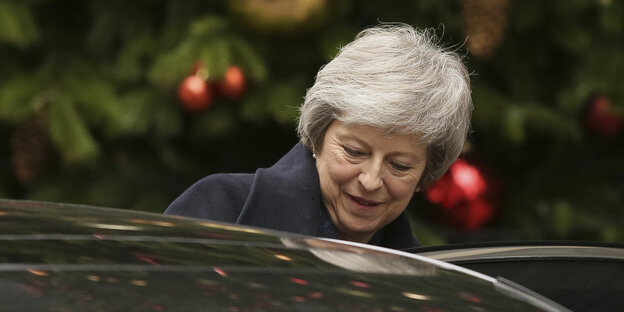Eine Frau steht vor einem Tannenbaum. Es ist die britische Premierministerin Theresa May Eine Frau steht vor einem Tannenbaum. Es ist die britische Premierministerin Theresa May