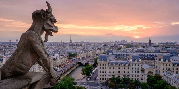 Ein steinerner Dämon blickt von weit oben auf Paris herab Ein steinerner Dämon blickt von weit oben auf Paris herab