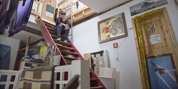 Eine Frau sitzt auf der Treppe des alternativen Wohnprojekts Assenland in Frankfurt am Main Eine Frau sitzt auf der Treppe des alternativen Wohnprojekts Assenland in Frankfurt am Main
