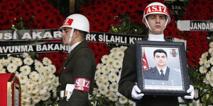türkische Soldaten stehen Wache mit einem Bild eines getöteten Kameraden, alles mit türkischen Nationalfarben