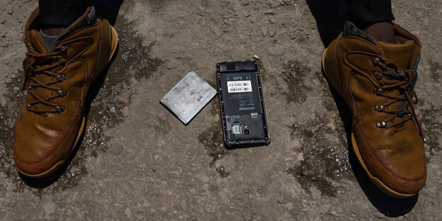 Das nasse Mobiltelefon eines Flüchtlings, der aus der Straße von Gibraltar, gerettet wurde, liegt zum Trocknen in der Sonne Das nasse Mobiltelefon eines Flüchtlings, der aus der Straße von Gibraltar, gerettet wurde, liegt zum Trocknen in der Sonne