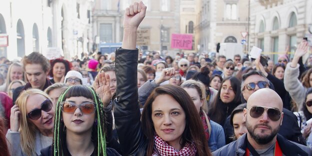 Asia Argento steht zwischen DemonstrantInnen und reckt die Faust nach oben Asia Argento steht zwischen DemonstrantInnen und reckt die Faust nach oben