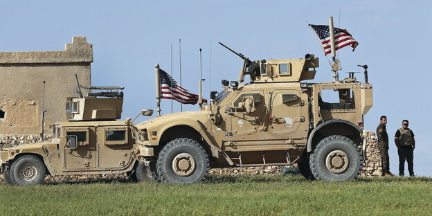 zwei beigefarbene Armee-Fahrzeuge mit US-Flagge zwei beigefarbene Armee-Fahrzeuge mit US-Flagge