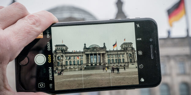 Ein Handybildschirm zeigt das Foto des Bundestags Ein Handybildschirm zeigt das Foto des Bundestags