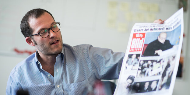 Mann mit Brille hält Bild-Zeitung Mann mit Brille hält Bild-Zeitung
