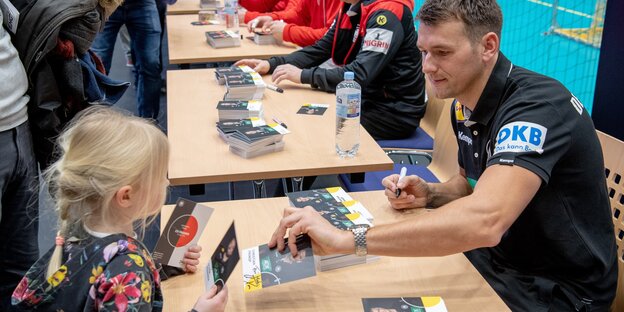 Handball-Bundestrainer Christian Prokop gibt einem jungen Mädchen ein Autogramm Handball-Bundestrainer Christian Prokop gibt einem jungen Mädchen ein Autogramm