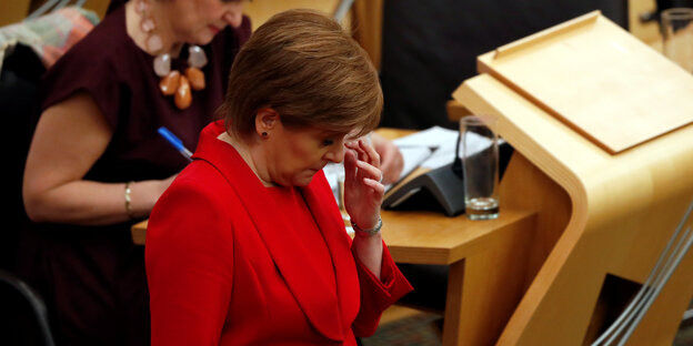 Schottlands Regierungschefin Nicola Sturgeon kratz sich an der Stirn. Sie hält gleich eine Rede im Parlament. Schottlands Regierungschefin Nicola Sturgeon kratz sich an der Stirn. Sie hält gleich eine Rede im Parlament.