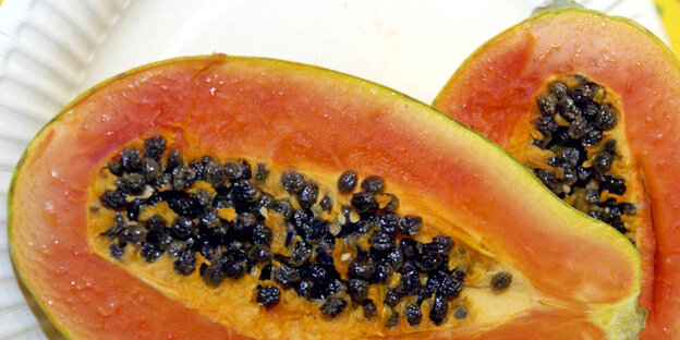 Eine aufgeschnittene, halbierte Papaya Eine aufgeschnittene, halbierte Papaya