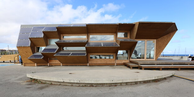 Ein Pavillion in Barcelonas Stadtteil Poblenou mit hervortretenden Dächern auf denen Sonnenkollektoren sitzen Ein Pavillion in Barcelonas Stadtteil Poblenou mit hervortretenden Dächern auf denen Sonnenkollektoren sitzen