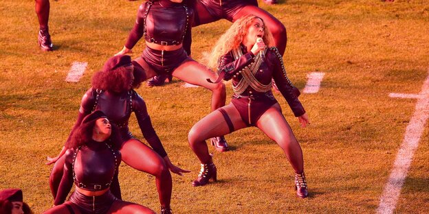 Beyoncé mit Tänzerinnen auf einem Football-Feld Beyoncé mit Tänzerinnen auf einem Football-Feld