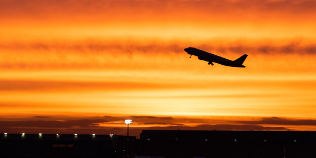 ein Flugzeug vor einem gelb-roten Himmel ein Flugzeug vor einem gelb-roten Himmel