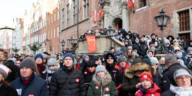 Menschen mit ernsten Minen stehen in den Straßen von Danzig Menschen mit ernsten Minen stehen in den Straßen von Danzig
