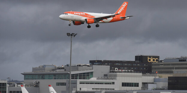 Flugzeug im Landeanflug vor düsterem Himmel