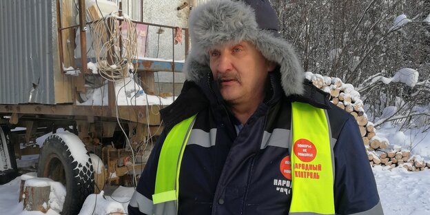 Älterer Mann mit geler Signalweste im Schnee Älterer Mann mit geler Signalweste im Schnee