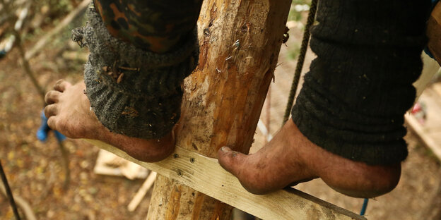 Füße eines Aktivisten stehen auf einer Sprosse im Hambacher Forst Füße eines Aktivisten stehen auf einer Sprosse im Hambacher Forst