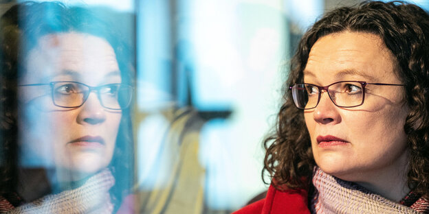 Andrea Nahles schaut durch ein Fenster und sieht ihr Spiegelbild Andrea Nahles schaut durch ein Fenster und sieht ihr Spiegelbild