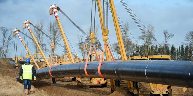 Ein Pipelinestück wird ins Erdreich gelegt Ein Pipelinestück wird ins Erdreich gelegt