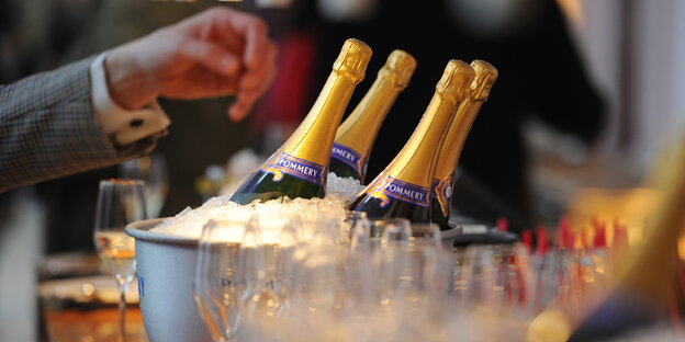 vier Champagnerflaschen in einem Kühler voller Eis vier Champagnerflaschen in einem Kühler voller Eis
