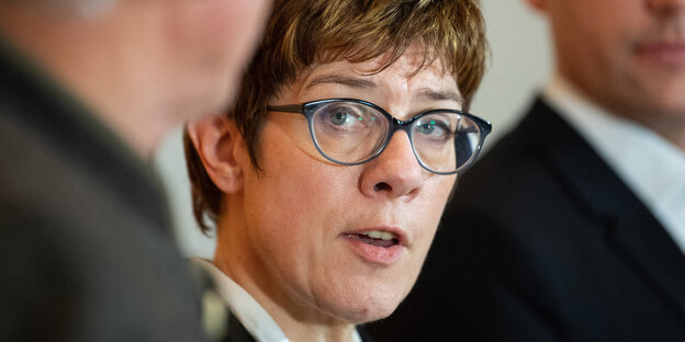 Annegret Kramp-Karrenbauer zwischen zwei Männern