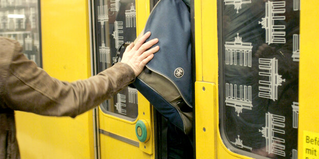Jemand klemmt mit dem Rucksack in einer U-Bahn-Tür Jemand klemmt mit dem Rucksack in einer U-Bahn-Tür