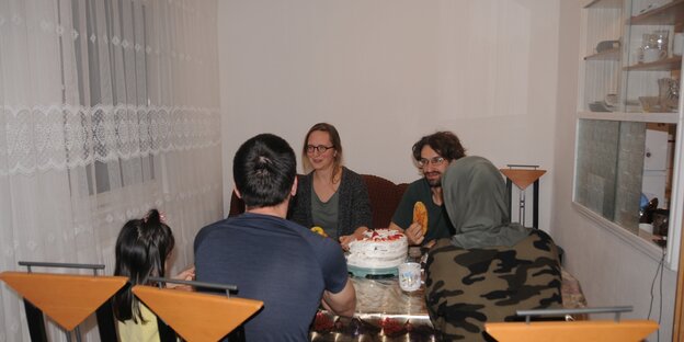 Menschen sitzen in einem Wohnzimmer Menschen sitzen in einem Wohnzimmer