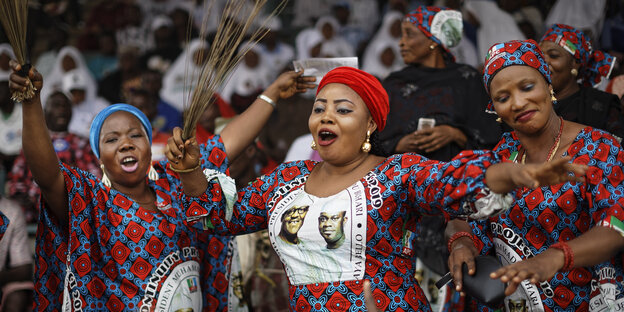 Drei Frauen tanzen bei einer Wahlkampfveranstaltung des Präsidenten von Nigeria Buhari Drei Frauen tanzen bei einer Wahlkampfveranstaltung des Präsidenten von Nigeria Buhari