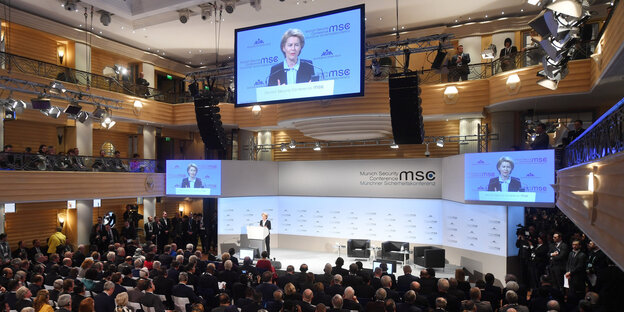 Publikum, von der leyen spricht und mehrere Bildschirme Publikum, von der leyen spricht und mehrere Bildschirme