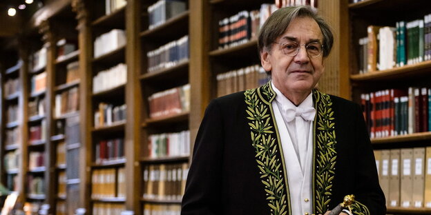 Alain Finkielkraut, ein Mann mit Brille und dunkelgrauen Haaren vor einem Bücherregal Alain Finkielkraut, ein Mann mit Brille und dunkelgrauen Haaren vor einem Bücherregal
