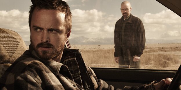 Szene aus "Breaking Bad": Jesse Pinkman sitzt am Steuer eines Autos im Hintergrund steht Walter White Szene aus "Breaking Bad": Jesse Pinkman sitzt am Steuer eines Autos im Hintergrund steht Walter White