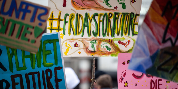 Bunte Demo-Plakate einer Klimaschutz-Demonstration in Stuttgart.