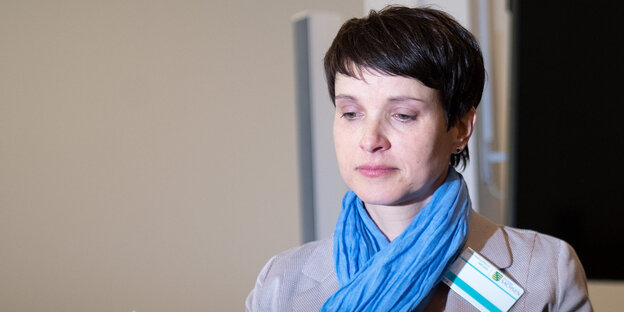 frauke petry sitzt im gerichtssaal und hält ein blatt papier in der hand