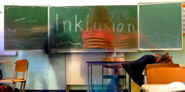 Das Wort "Inklusion" steht in einer Inklusions-Klasse auf der Tafel. Schüler gehen daran vorbei Das Wort "Inklusion" steht in einer Inklusions-Klasse auf der Tafel. Schüler gehen daran vorbei